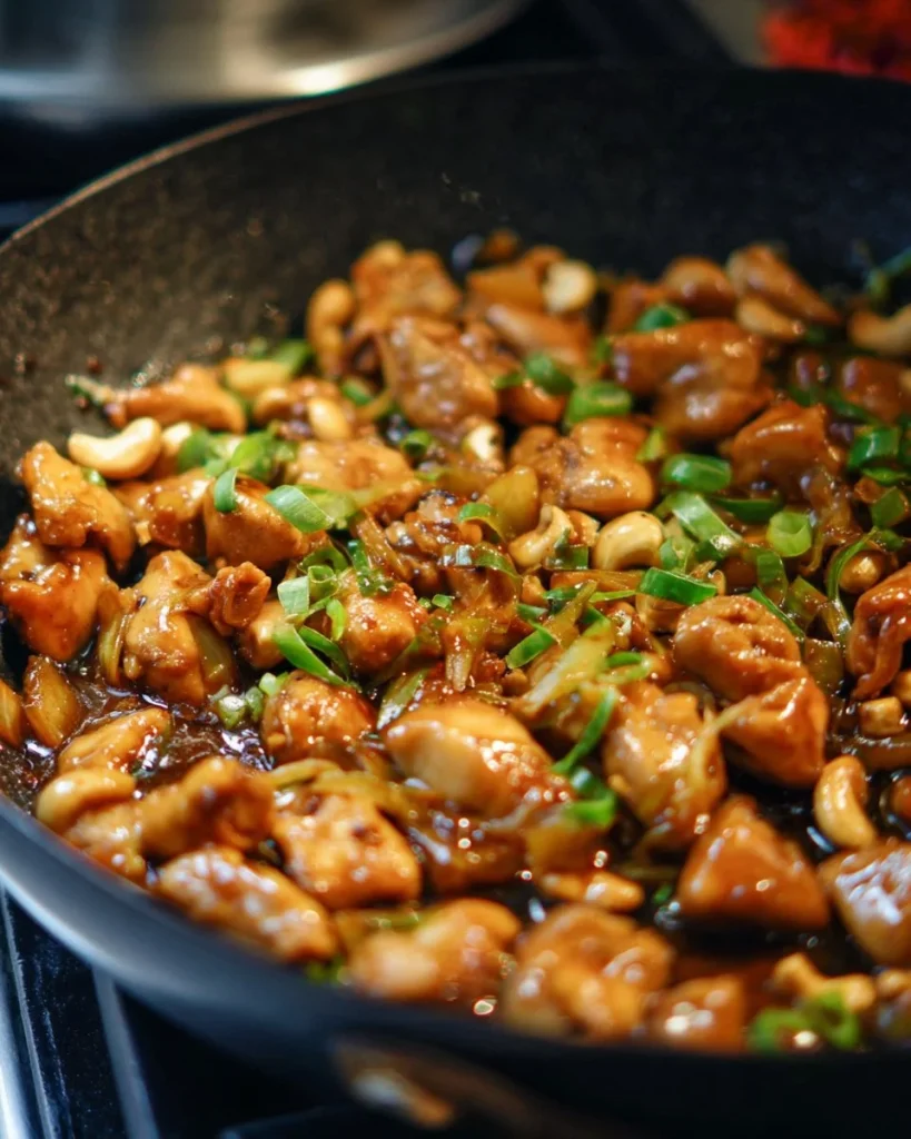 Plate of easy cashew chicken garnished with green onions and served with rice