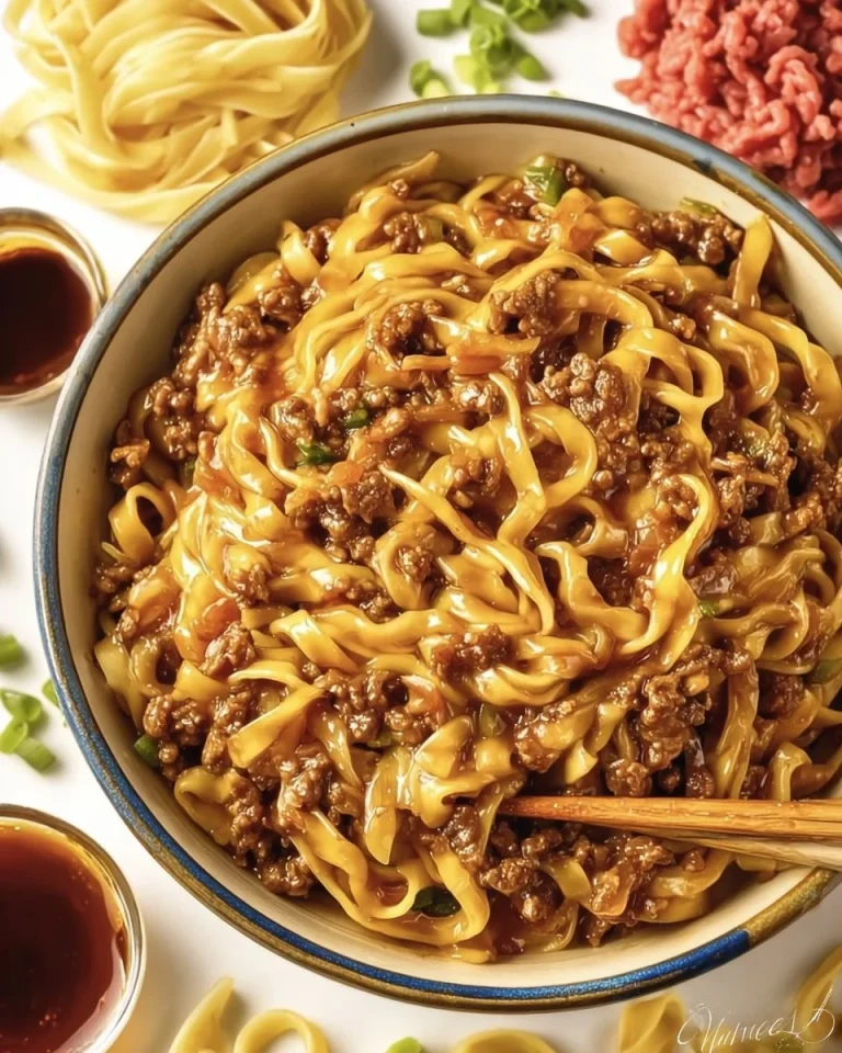 Mongolian ground beef noodles garnished with green onions and sesame seeds.