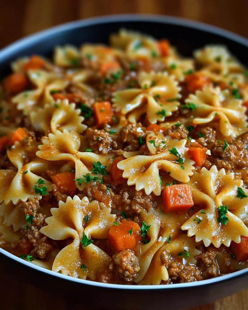 One-Pot Beef Bowtie Pasta cooked in a skillet, garnished with herbs.