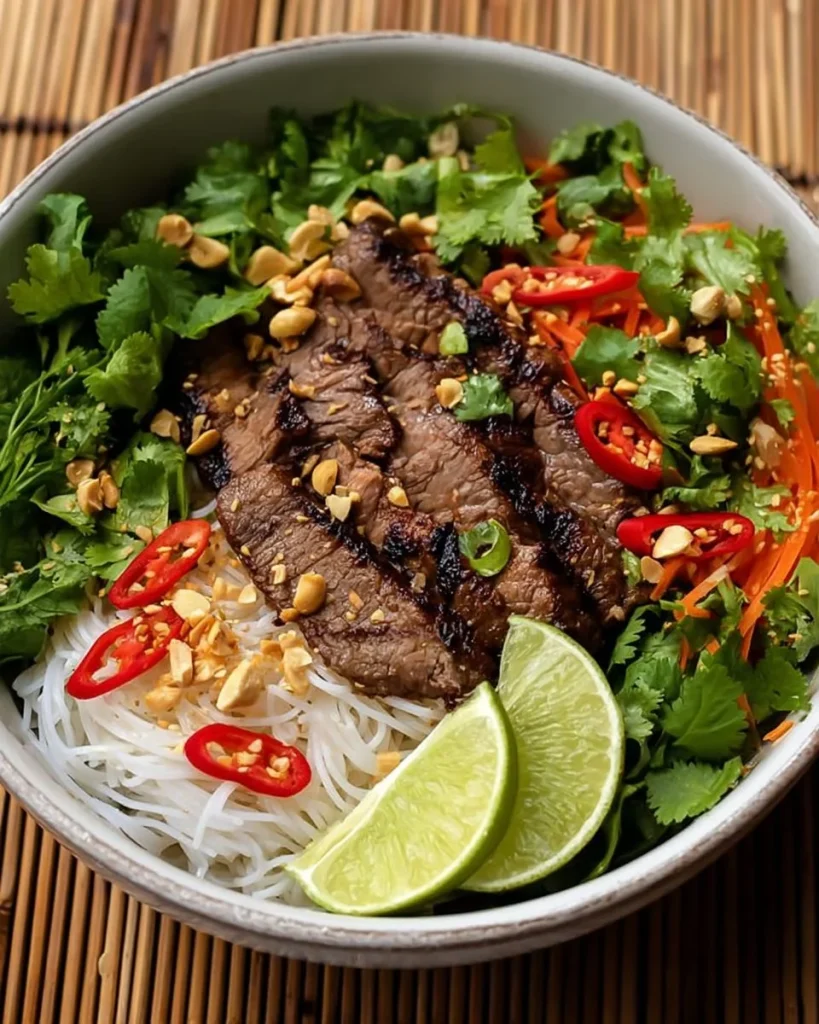 Plate of Vietnamese lemongrass beef served with noodles and fresh herbs