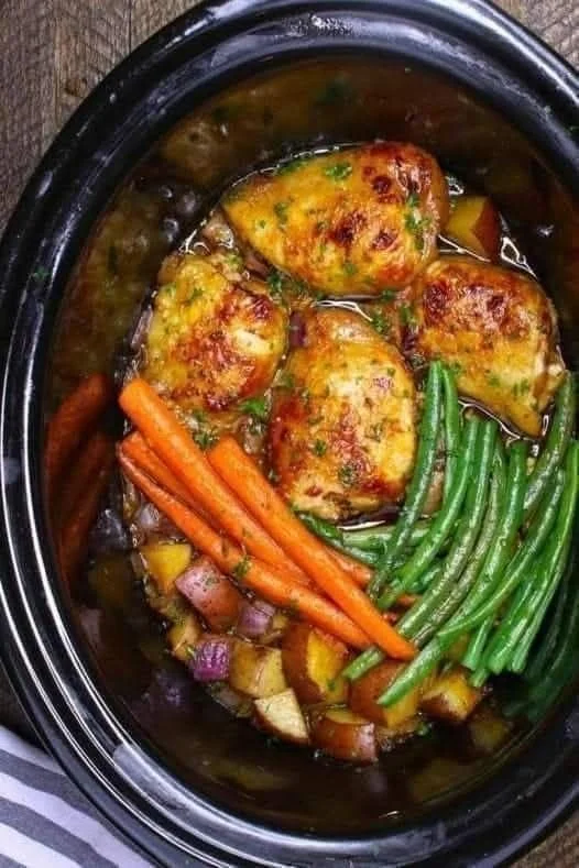 Delicious slow cooker honey garlic chicken garnished with herbs.