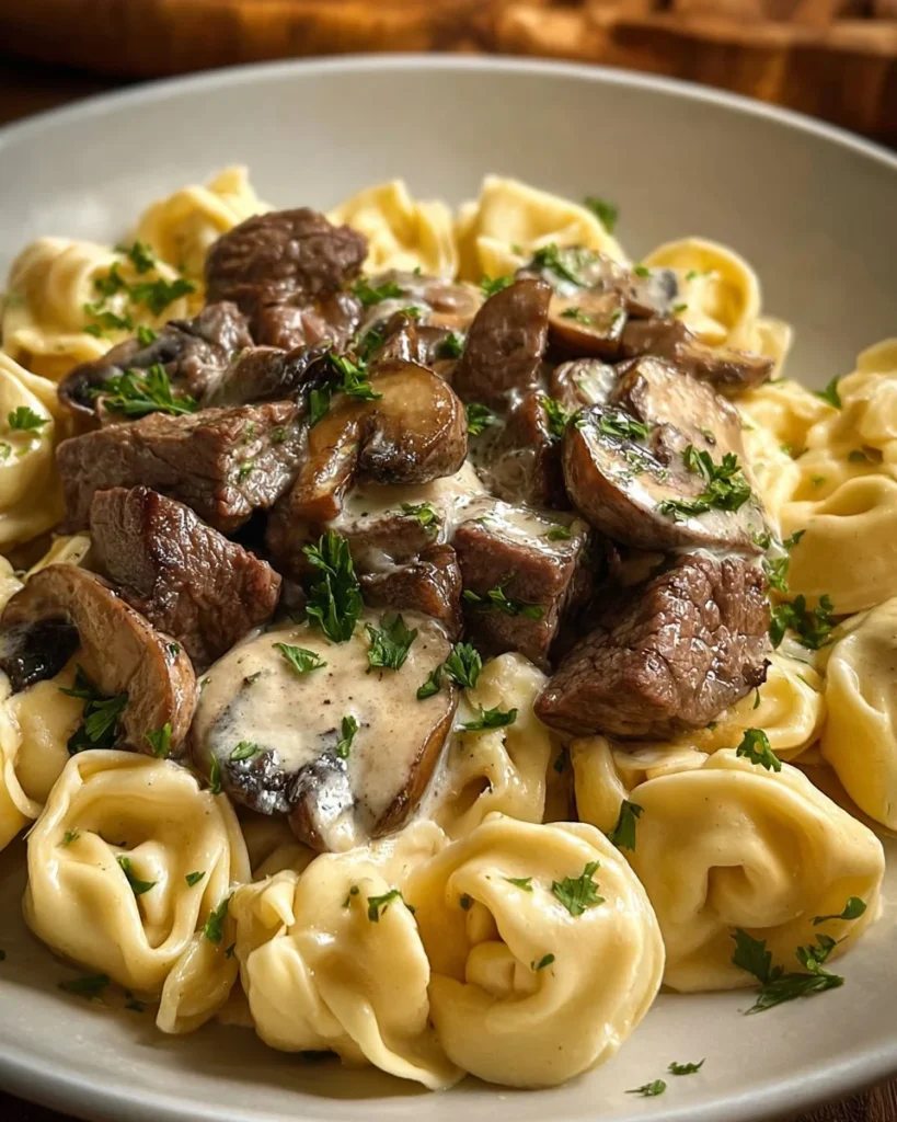 Dish of Steak Tortellini Alfredo with mushrooms in a creamy sauce
