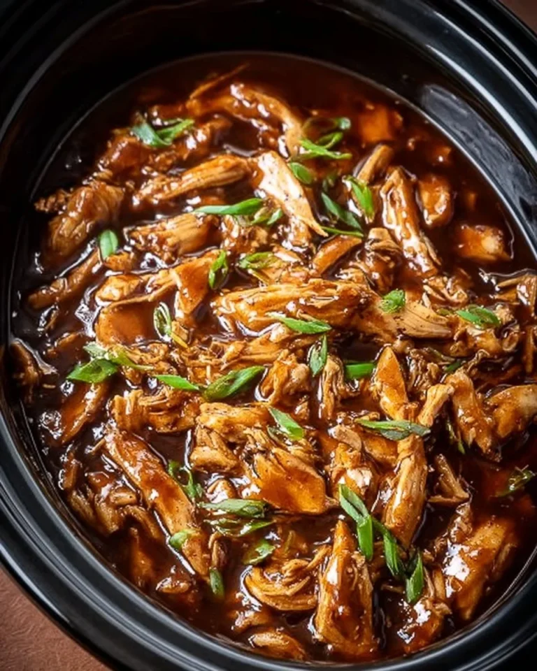 Delicious Crock Pot Bourbon Chicken served on a plate with a garnish.