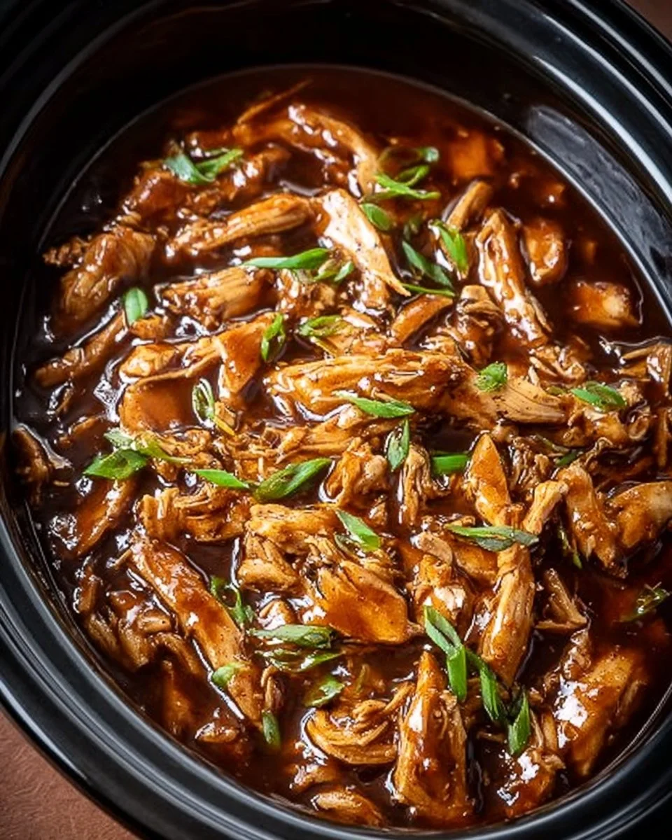 Delicious Crock Pot Bourbon Chicken served on a plate with a garnish.