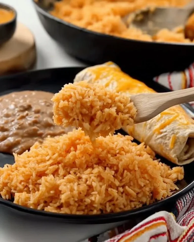 Bowl of easy Mexican rice garnished with fresh herbs and lime