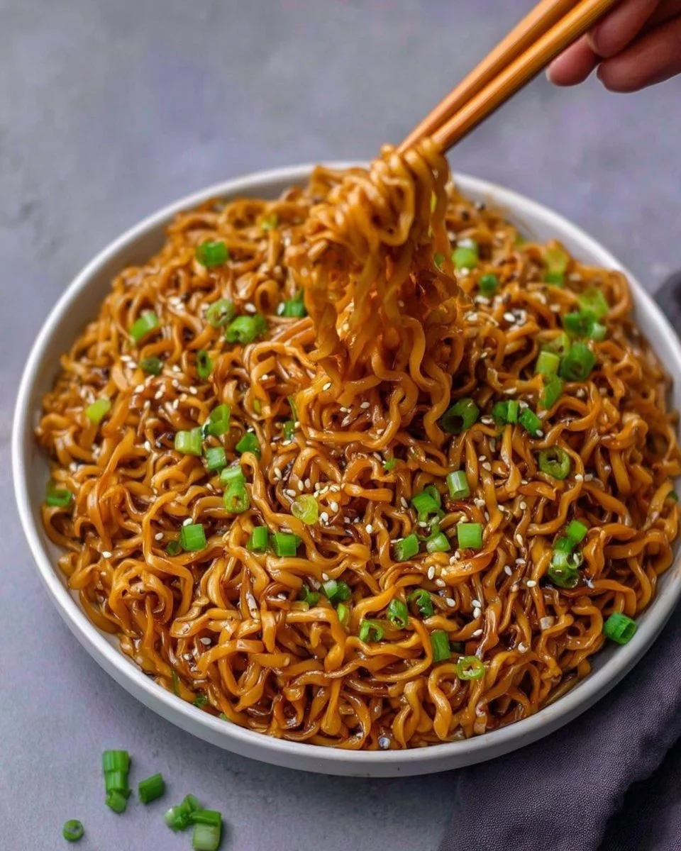 Bowl of easy saucy ramen noodles topped with fresh vegetables and herbs