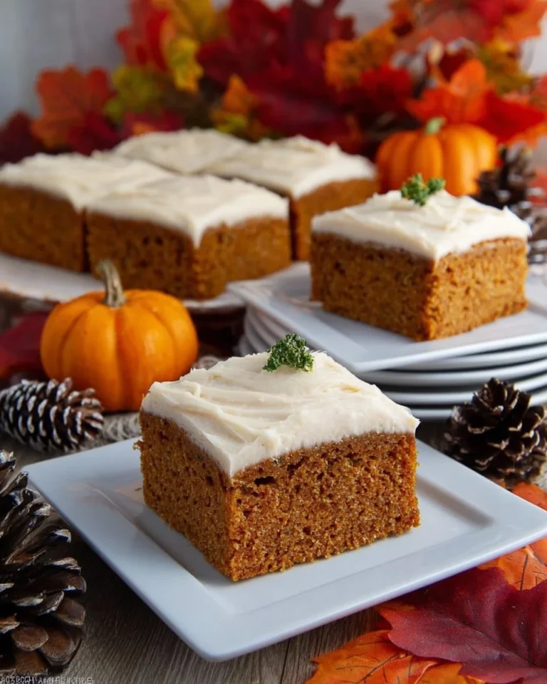Pumpkin bars with cinnamon cream cheese frosting on a rustic wooden table
