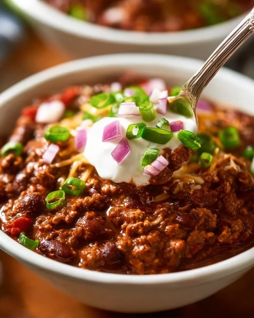 Bowl of Texas Roadhouse Chili topped with onions and cheese