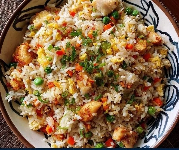 Crispy Garlic Chicken Fried Rice Bowl topped with fresh herbs