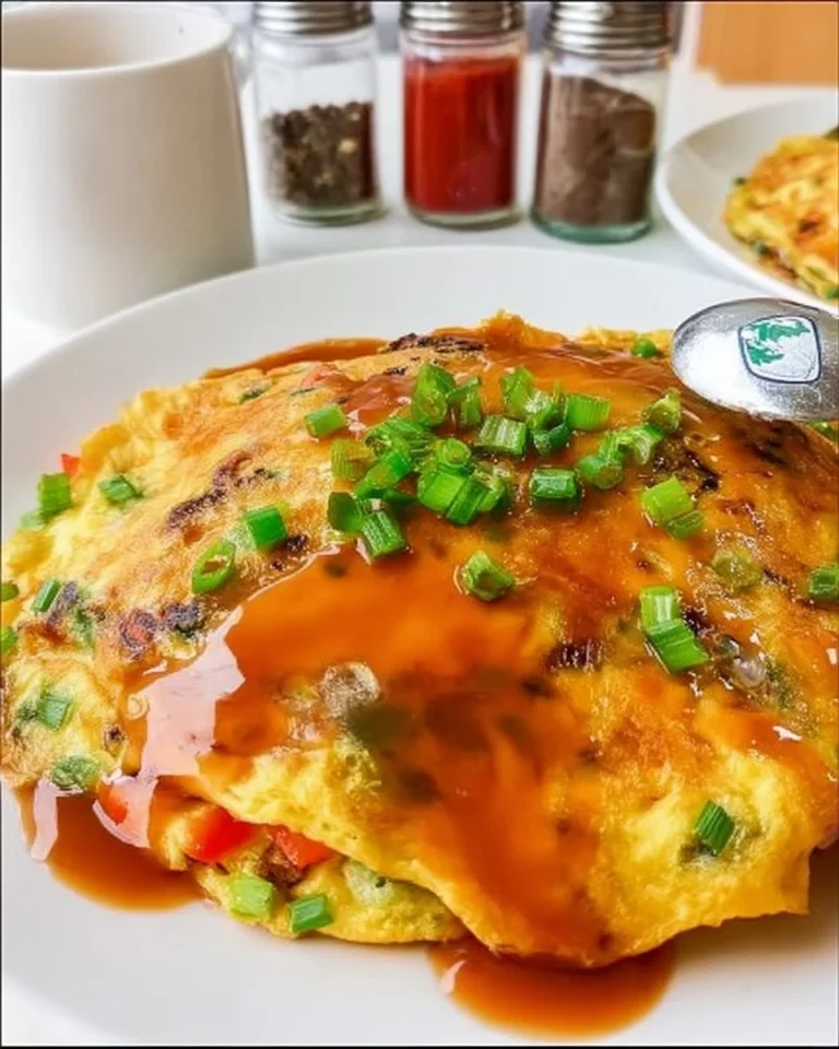 Delicious homemade Egg Foo Young served with savory sauce and vegetables.