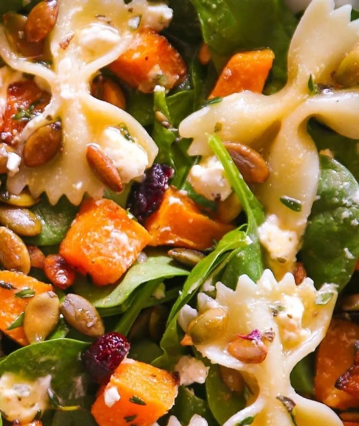 Colorful fall salad topped with maple-lime dressing and seasonal ingredients.