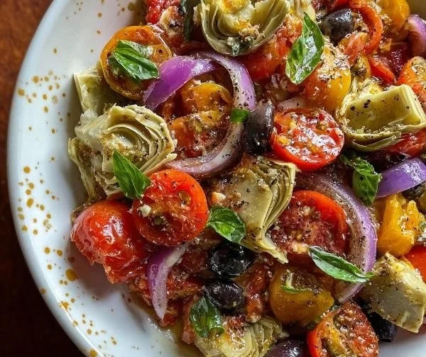 Tuscan artichoke tomato salad garnished with fresh herbs
