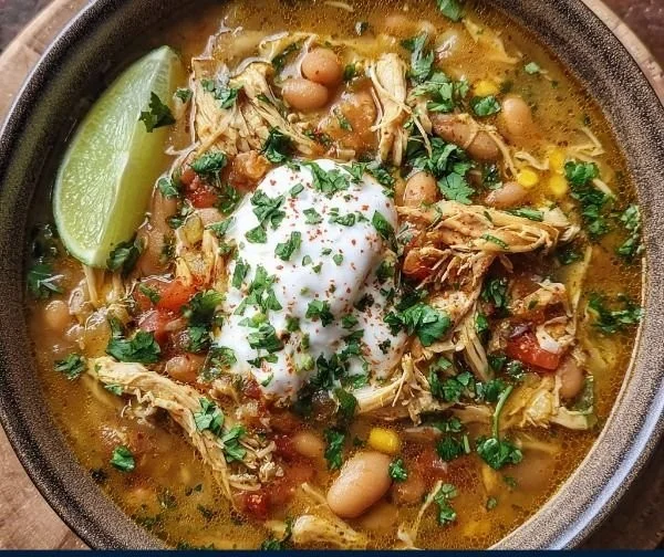 Delicious bowl of white chicken chili garnished with cilantro and lime