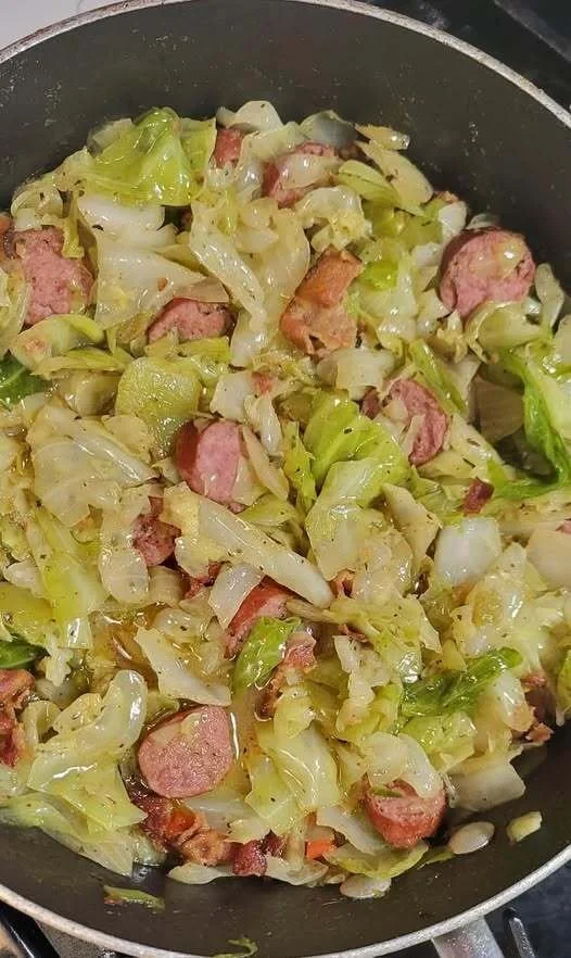 Dish of cabbage with peppers, onions, sausage, and bacon served in a bowl