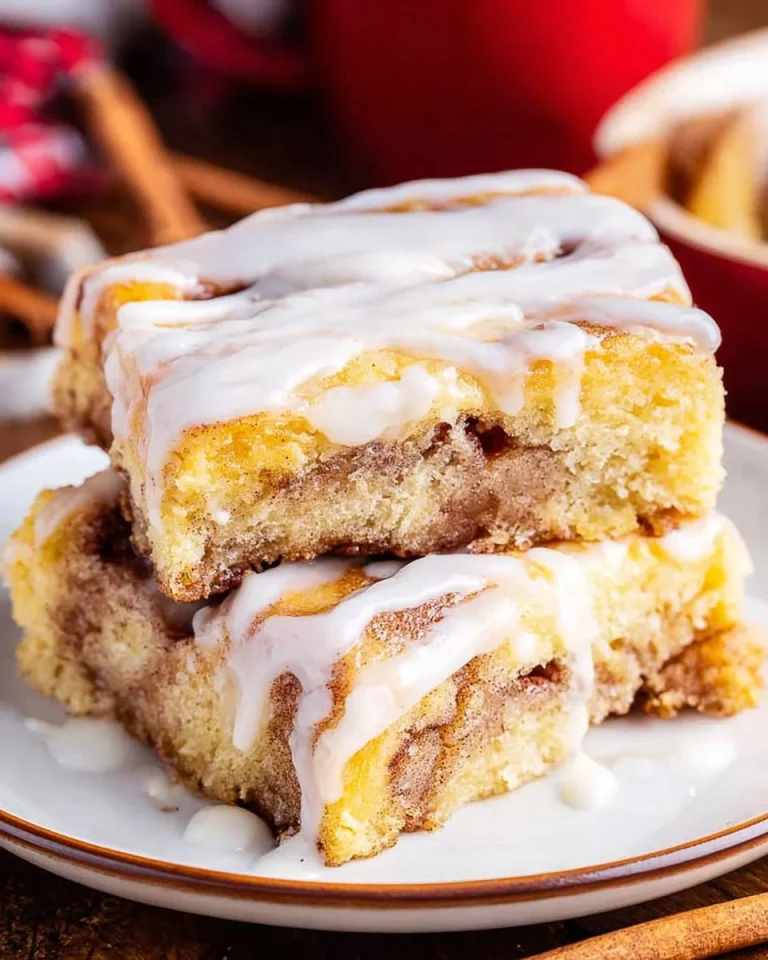 Delicious cinnamon roll cake topped with icing on a plate