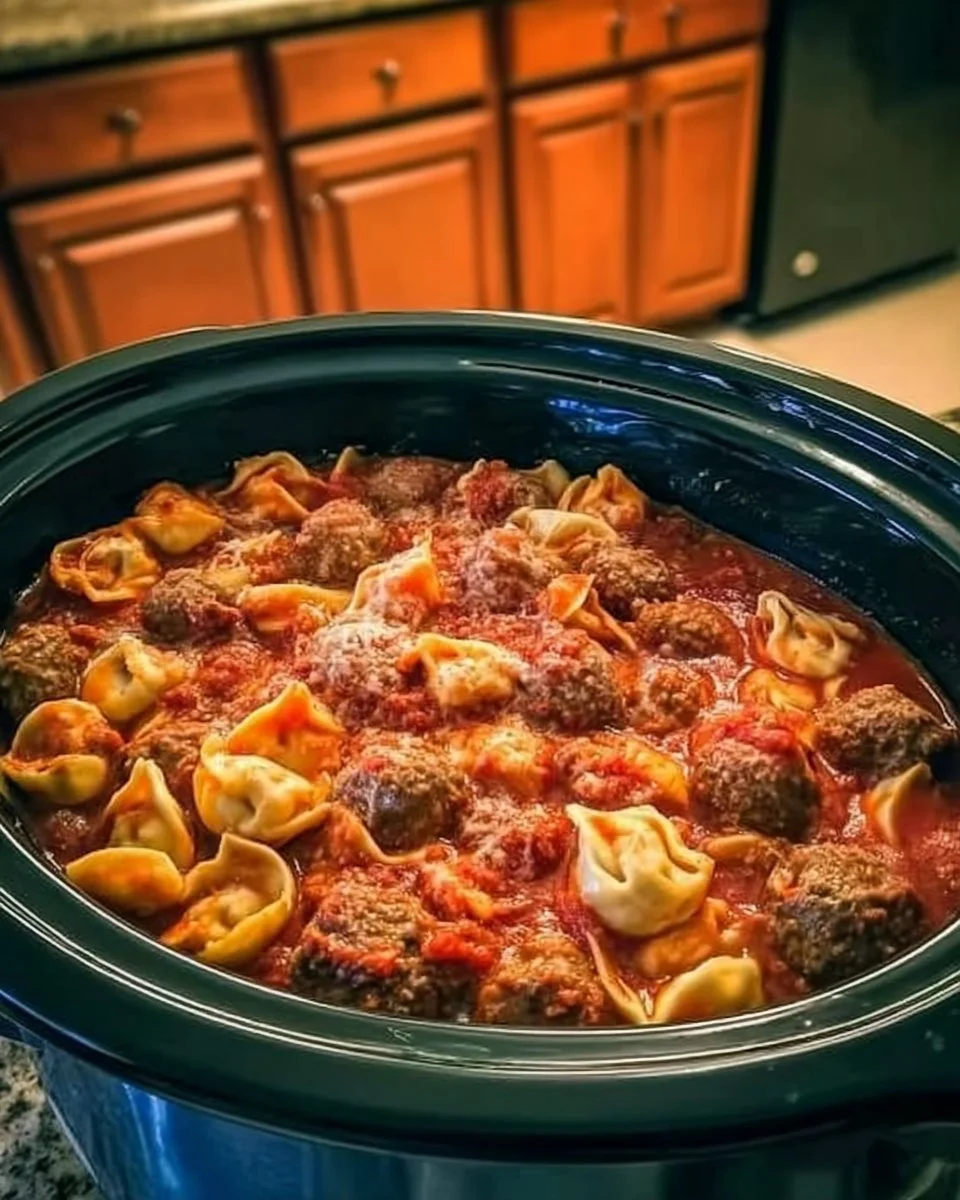 A hearty bowl of Crockpot Cheese Tortellini and Sausage topped with herbs.