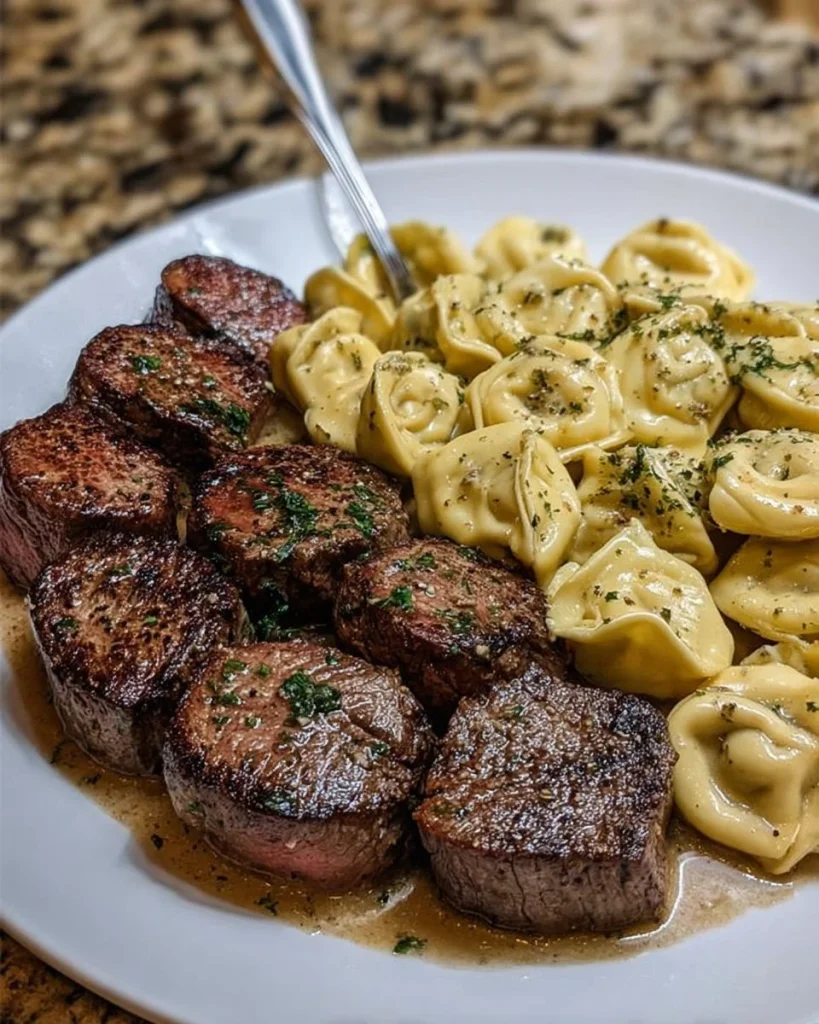 Delicious Garlic Butter Steak Bites served with creamy Alfredo tortellini.