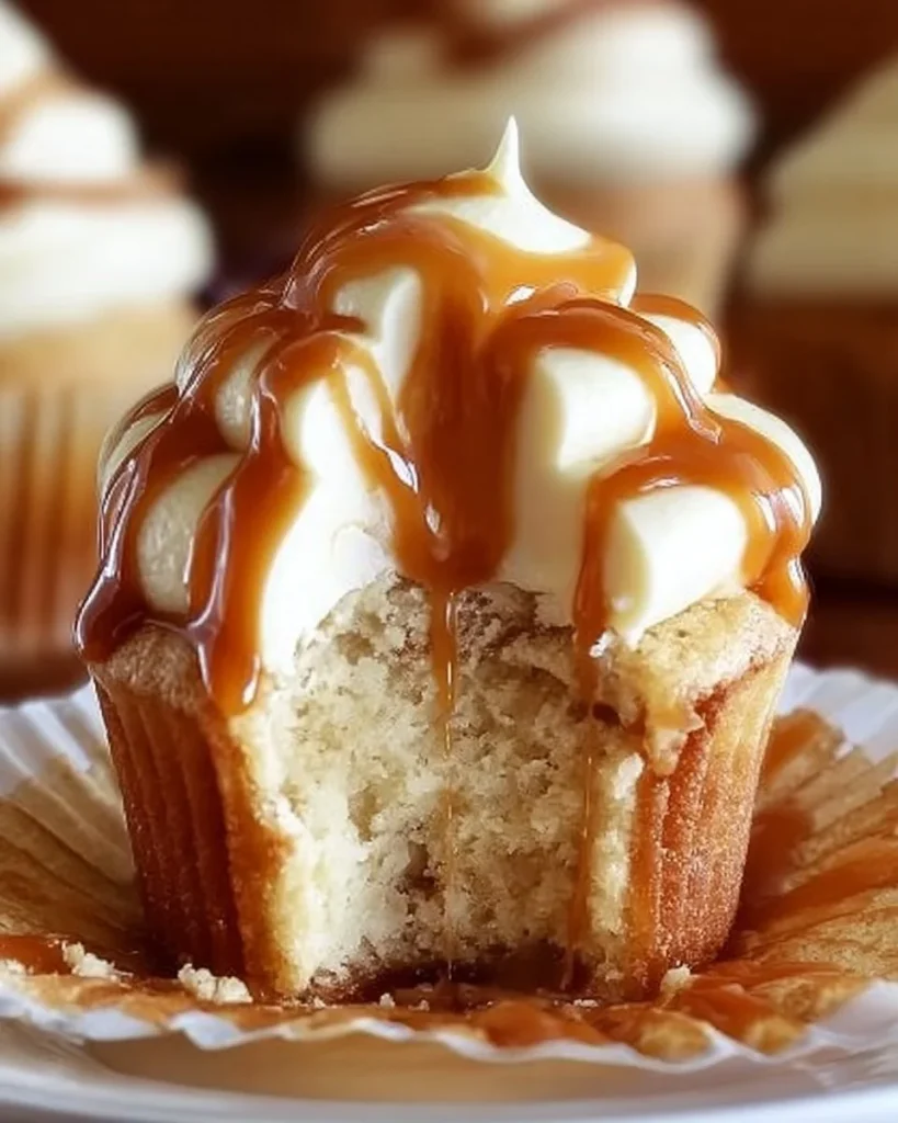 Delicious salted caramel cream cheese cupcakes topped with caramel drizzle.