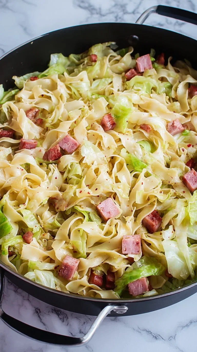 Delicious plate of Fried Cabbage, Ham, and Noodles garnished with herbs.
