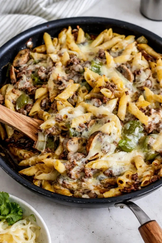 Delicious Philly Cheesesteak Pasta topped with melted cheese and peppers