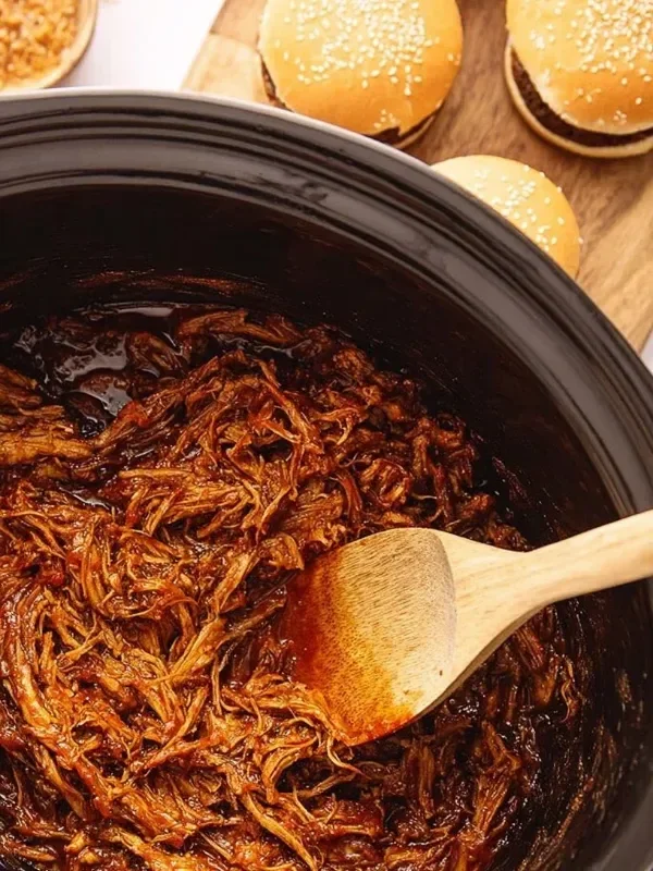 Juicy pulled BBQ chicken prepared in a slow cooker, served in a bun.