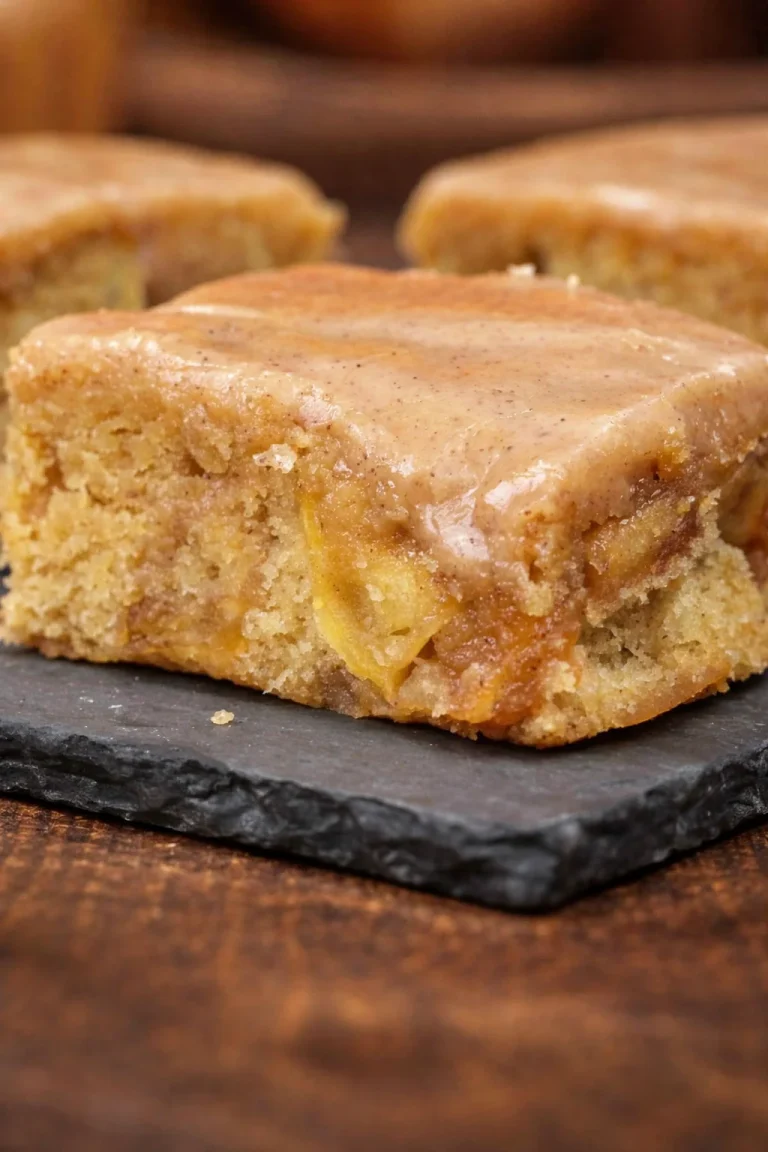 Delicious Apple Brownies drizzled with Maple Glaze on a rustic wooden table.