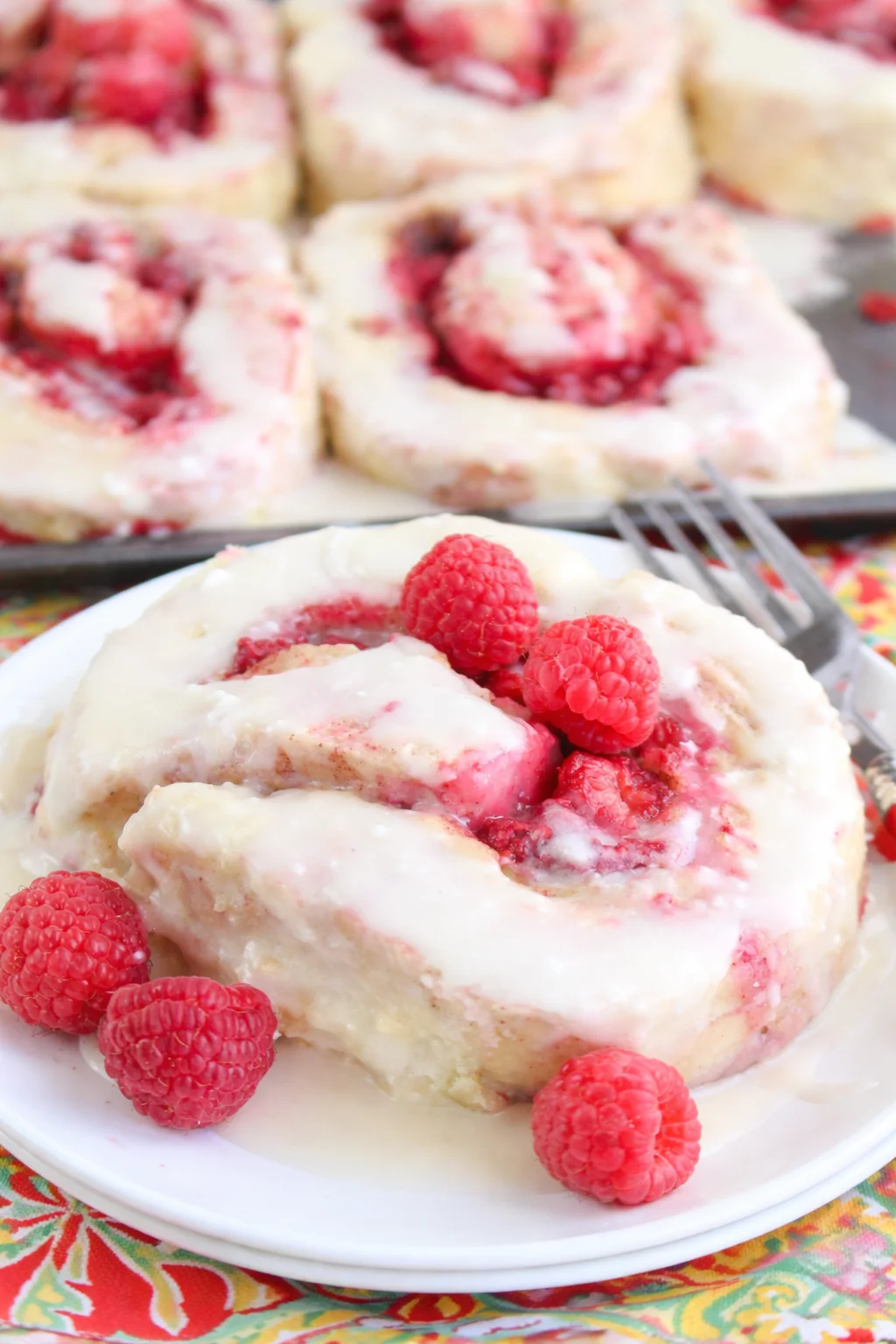 Freshly baked decadent raspberry cinnamon rolls topped with icing