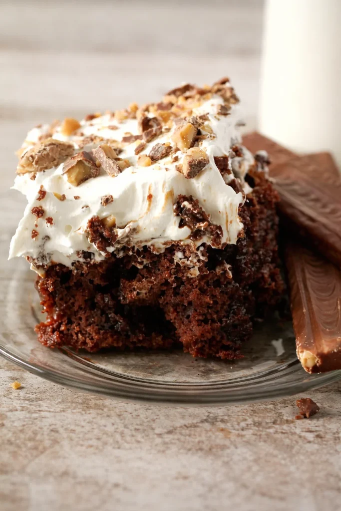 Heath Bar Poke Cake topped with chocolate and toffee bits