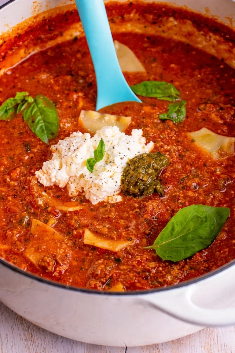 Bowl of hearty lasagna soup garnished with fresh basil and melted cheese