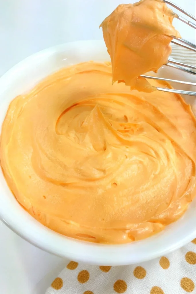 Delicious orange creamsicle buttercream frosting on a cake