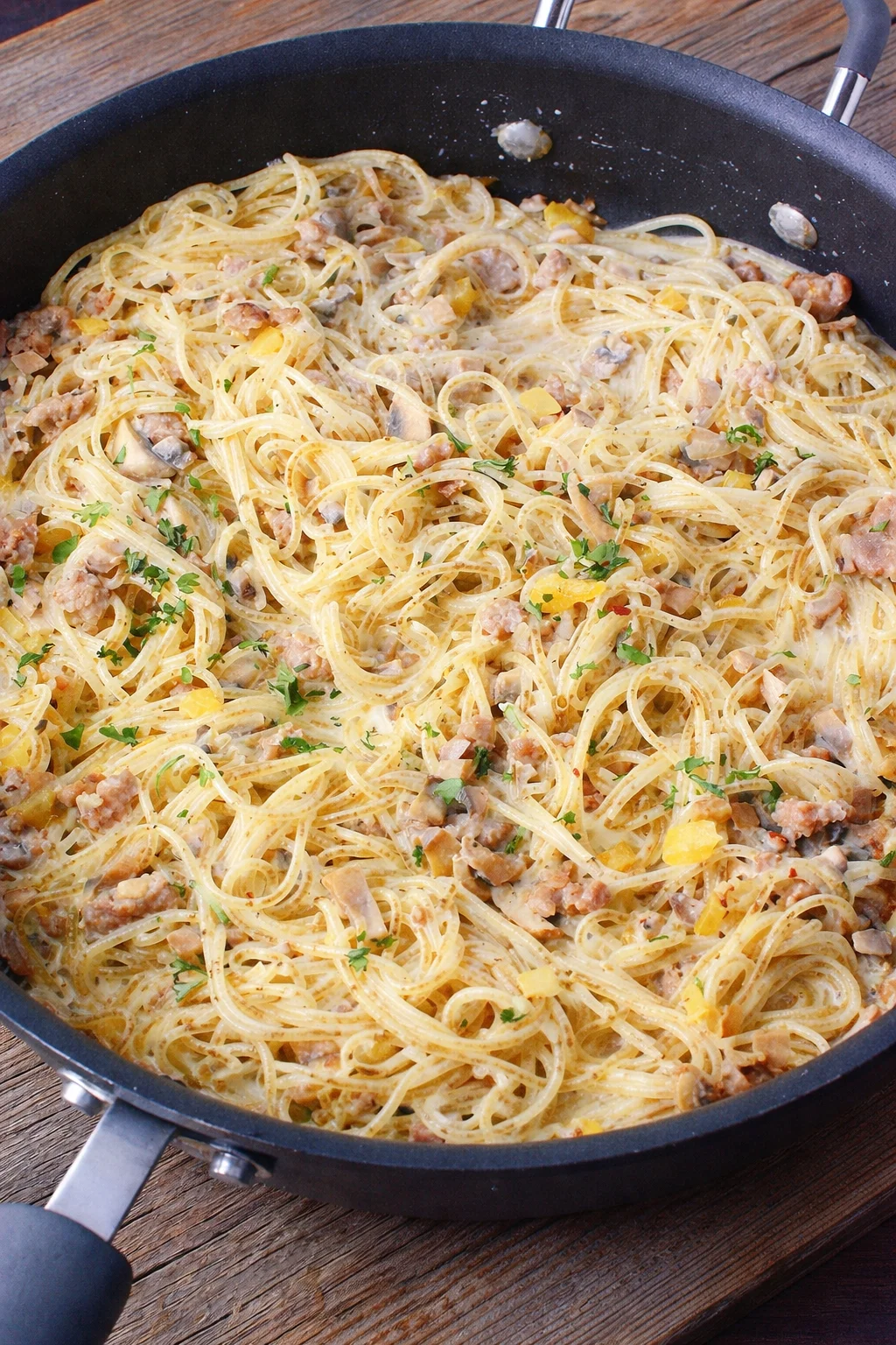 A bowl of creamy Sausage Boursin Pasta topped with herbs and sausage slices