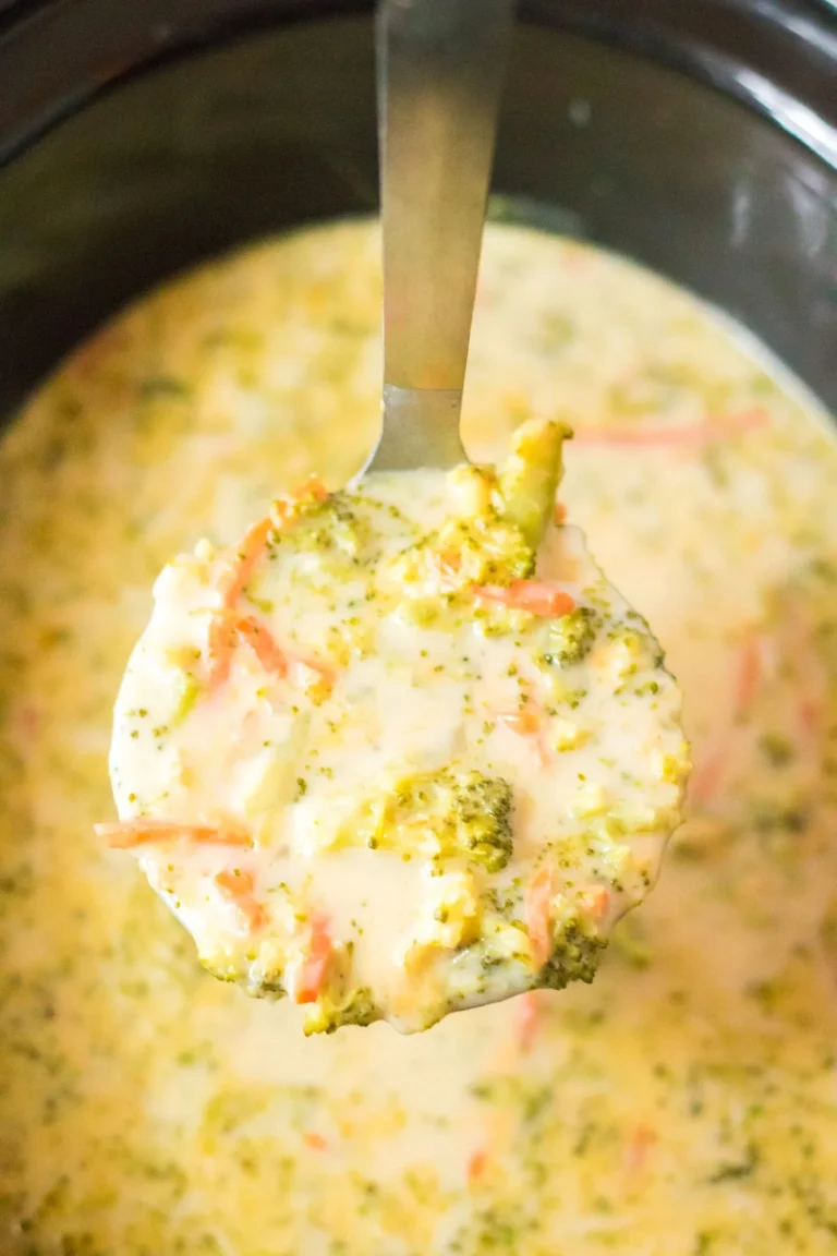 Bowl of slow cooker Panera-style broccoli cheddar soup topped with cheese.