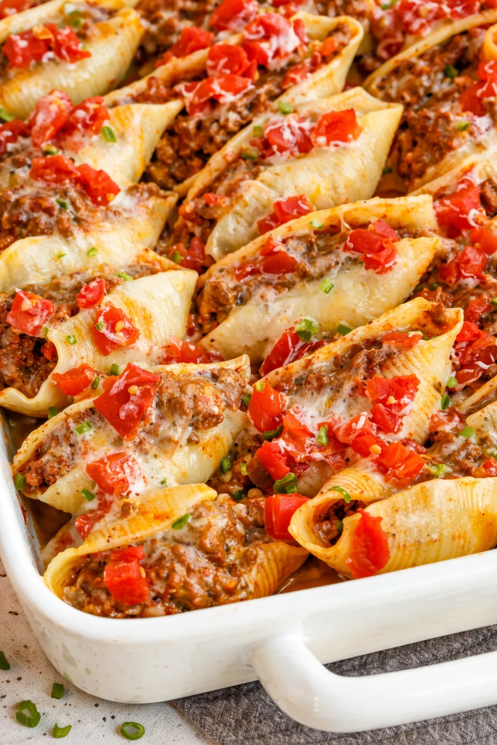 These delicious Taco Stuffed Shells are jumbo pasta shells stuffed with seasoned ground beef, onions, salsa, cheddar, and Monterey Jack Cheese. Bake up a batch tonight and get ready to hear the praises... Baked Taco Stuffed Shells filled with ground beef, cheese, and salsa