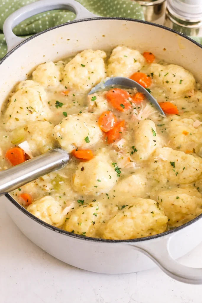 Bowl of Chicken and Dumpling Soup with creamy broth, carrots, and fluffy dumplings.