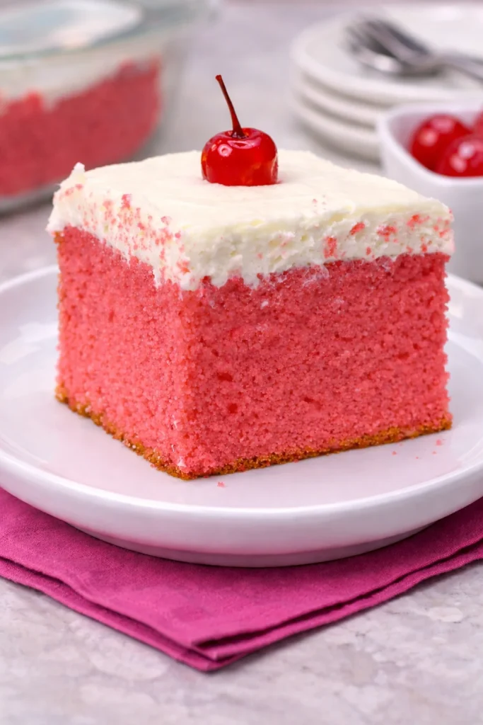 Slice of Very Cherry Cake topped with fresh cherries and whipped cream