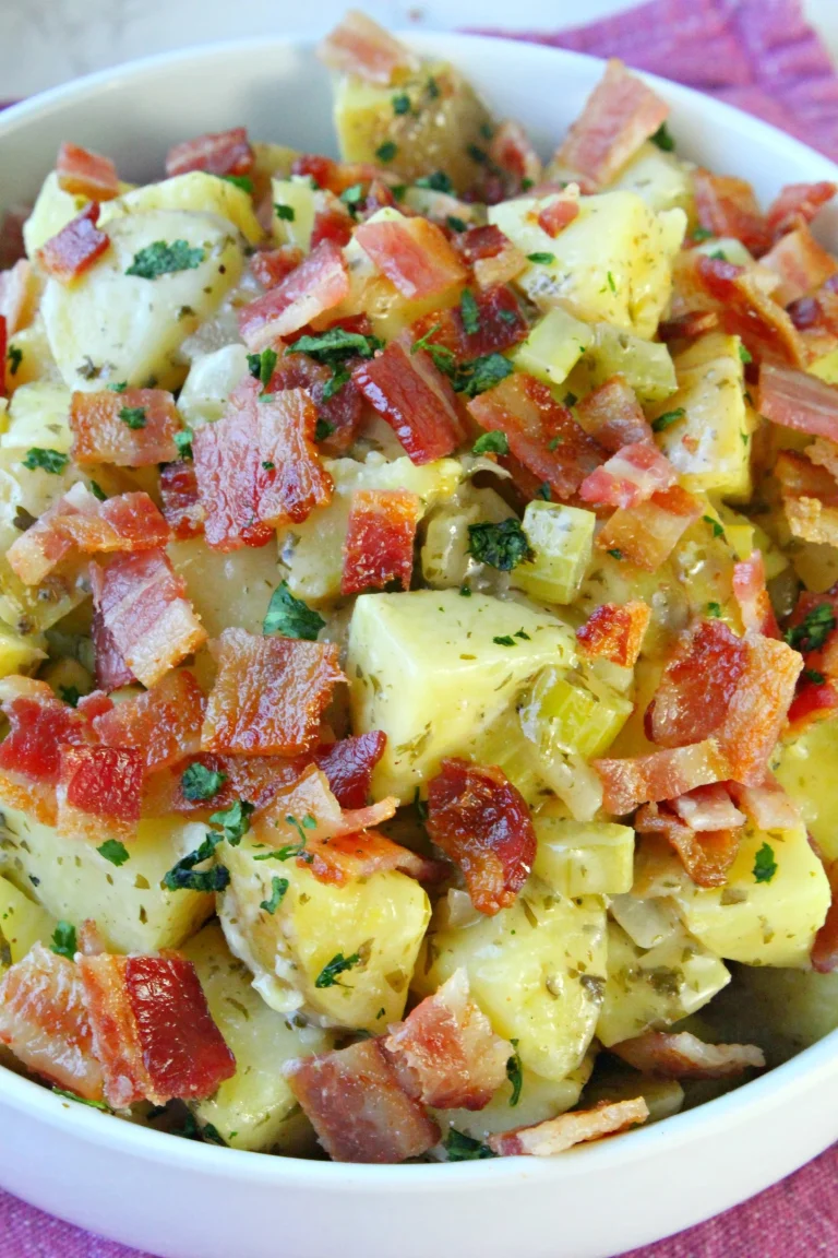 Zesty German Potato Salad Bowl of zesty German potato salad garnished with herbs.