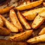 Baked Parmesan Potato Wedges served on a plate with herbs