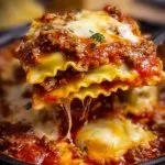 Crockpot ravioli lasagna served with fresh herbs and cheese.