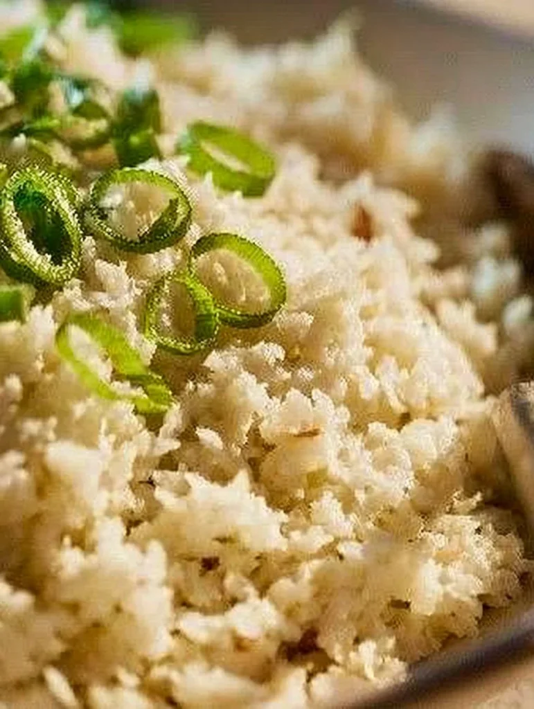 A bowl of cauliflower rice garnished with herbs, perfect for healthy meals.