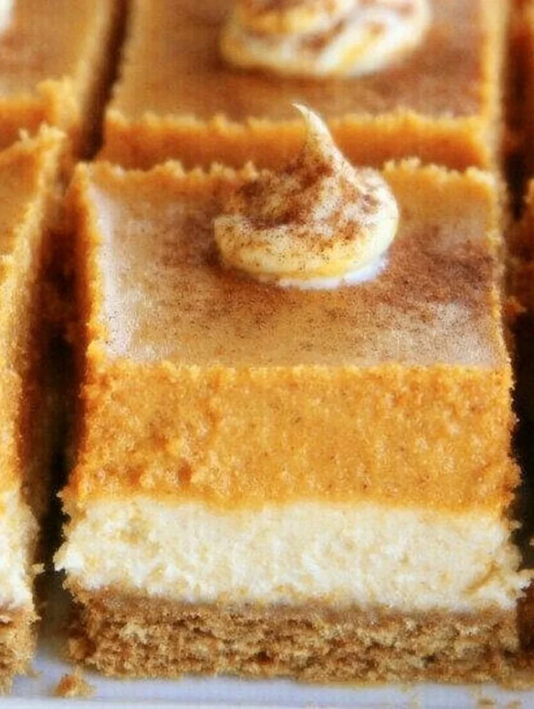 Delicious homemade pumpkin cheesecake bars topped with whipped cream.